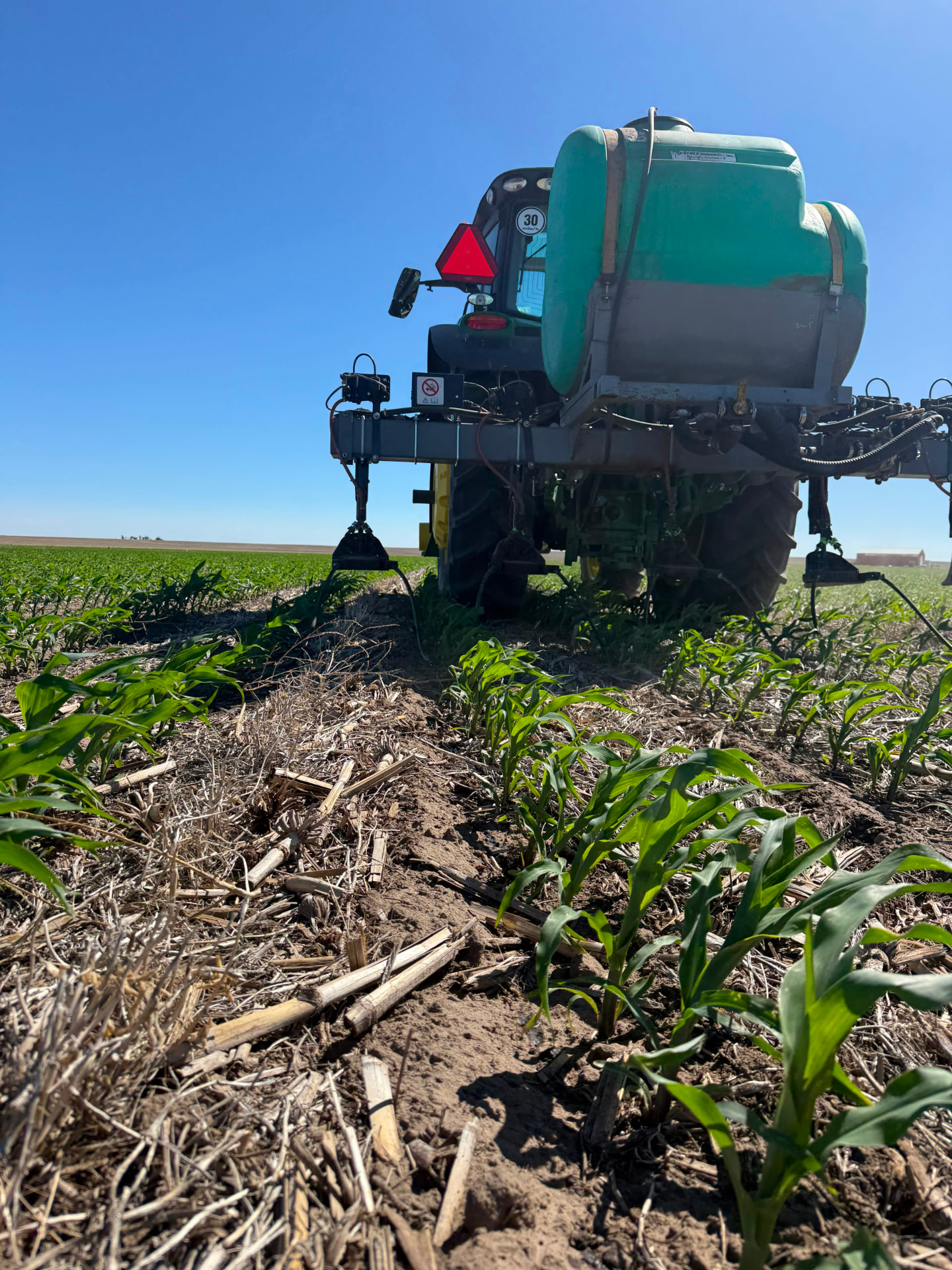 Tractor with liquid application rig treating a corn crop